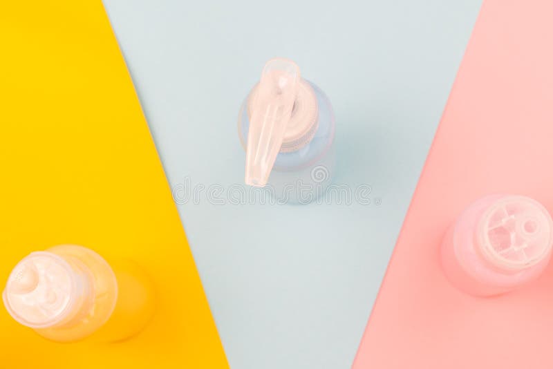 Jars with blue, pink and yellow cosmetics on coloured backgrounds royalty free stock photography