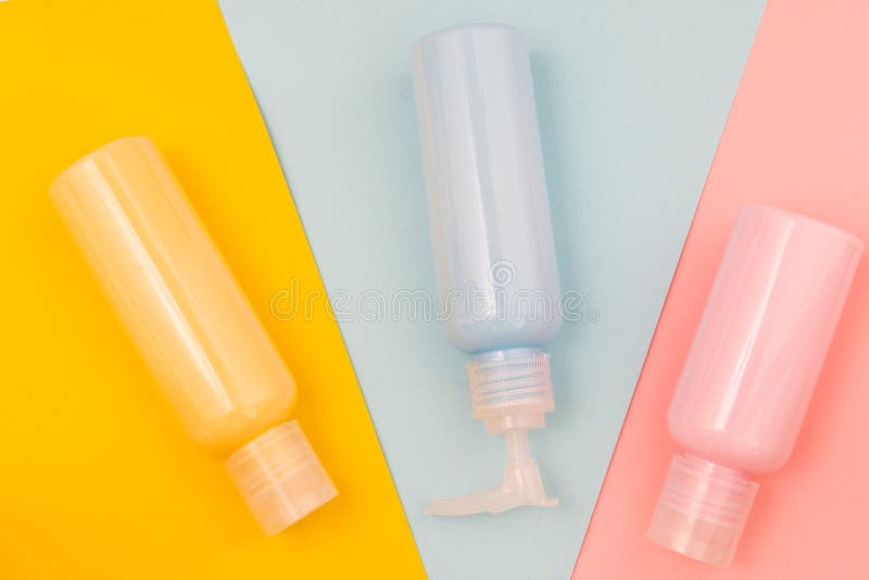 Jars with blue, pink and yellow cosmetics on coloured backgrounds royalty free stock image