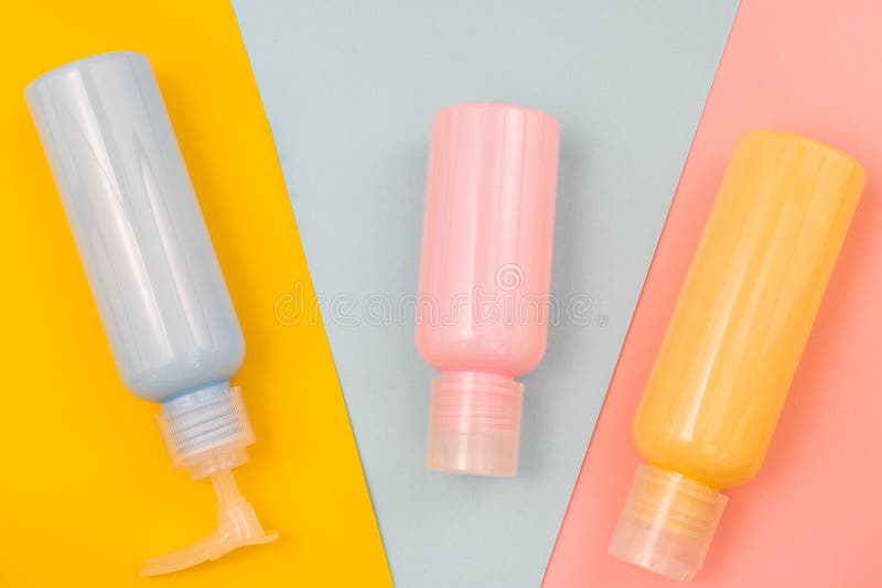 Jars with blue, pink and yellow cosmetics on coloured backgrounds royalty free stock photos