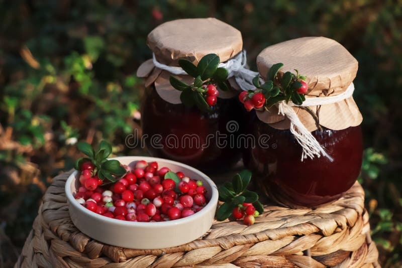 Jars of Delicious Lingonberry Jam and Red Berries on Wicker Basket