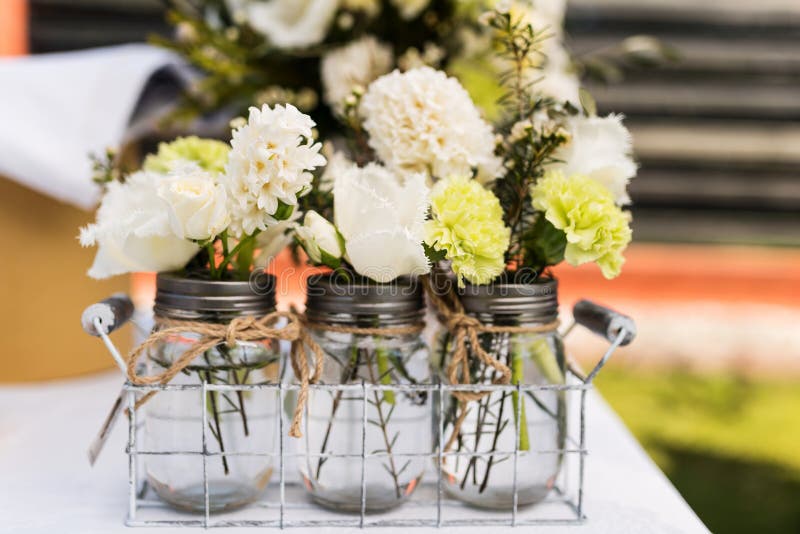 Jars with small white and green bouquets