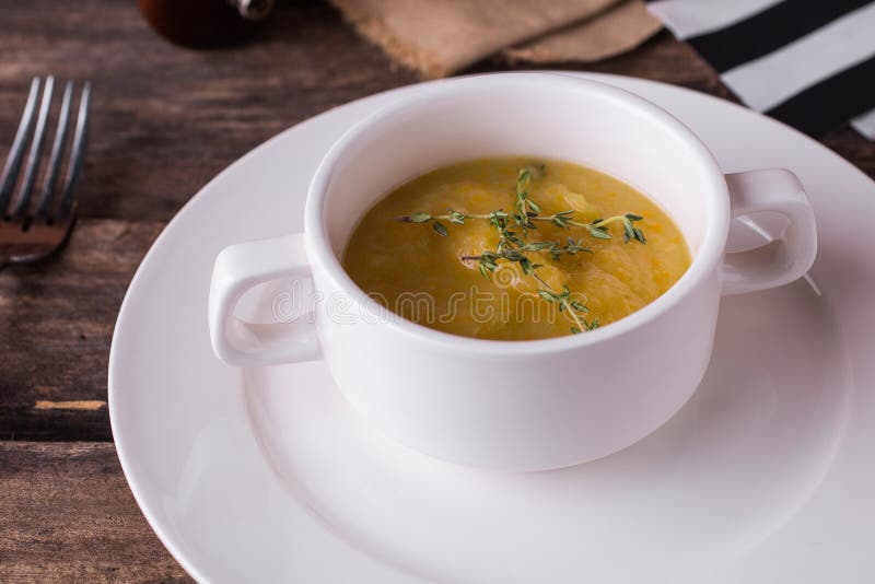 Jarzynowa kremowa polewka z oregano w białym talerzu zdjęcie stock Jarzynowa kremowa polewka z oregano w białym talerzu zdjęcie stock