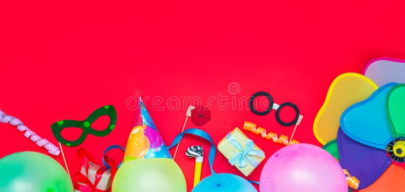 Jaskrawy czerwony Świąteczny tło z przyjęć narzędziami i dekoracją - baloons, śmieszne karnawałowe maski, świąteczny świecidełko obraz stock Jaskrawy czerwony Świąteczny tło z przyjęć narzędziami i dekoracją - baloons, śmieszne karnawałowe maski, świąteczny świecidełko obraz stock