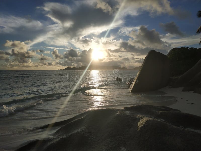 Jaskrawy olśniewający zmierzch przy Ladigue Seychelles z lekkim promieniem fotografia stock Jaskrawy olśniewający zmierzch przy Ladigue Seychelles z lekkim promieniem fotografia stock