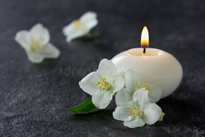Jasminblumen und brennende Kerzen