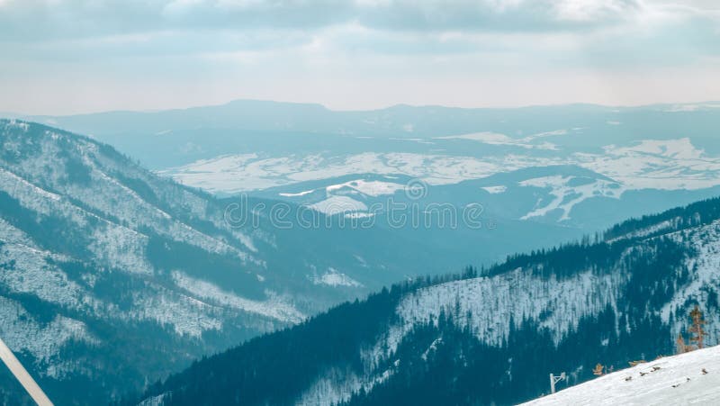 Stredisko Jasná, LIPTOV, SLOVENSKO - február 2019: Modrá obloha so snehovými mrakmi a nový moderný vlek Funitel v Jasnej, región Liptov,