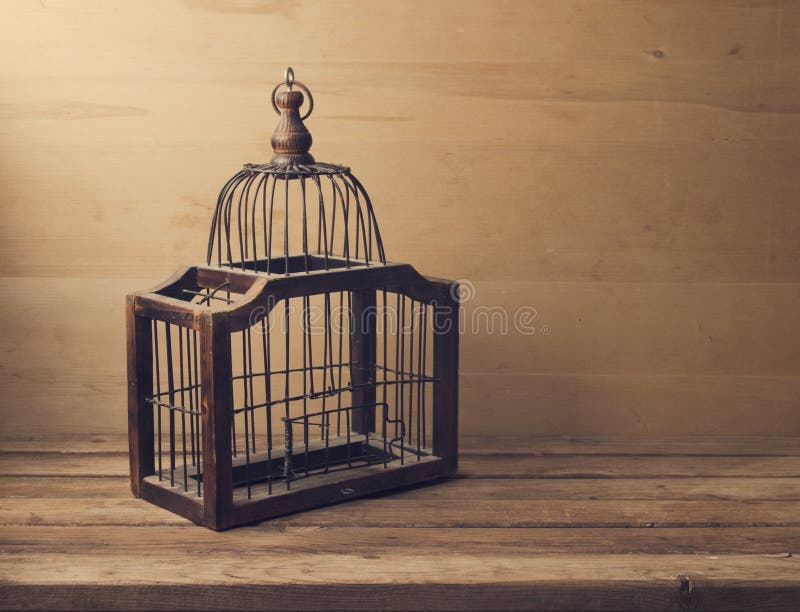 Wooden empty bird cage on wooden table and background. Wooden empty bird cage on wooden table and background