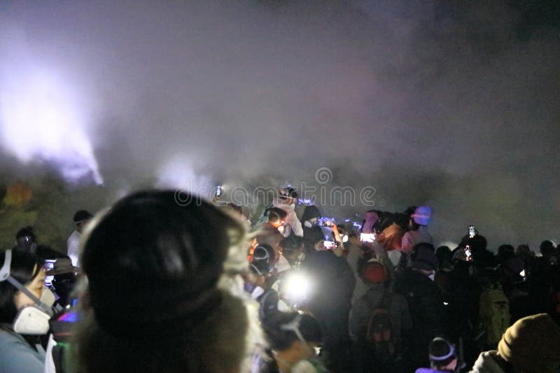 印尼爪哇岛伊真火山 - 2024年2月4日：人们在夜间行走，前往火山的蓝色火焰 免版税库存图片