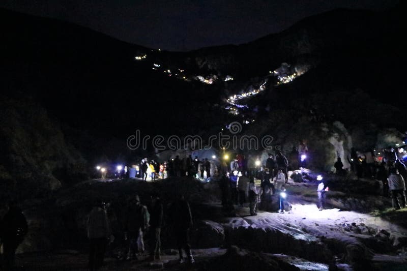 印尼爪哇岛伊根火山 - 2024年2月4日：人们在夜间行走，前往火山的蓝色火焰 库存照片