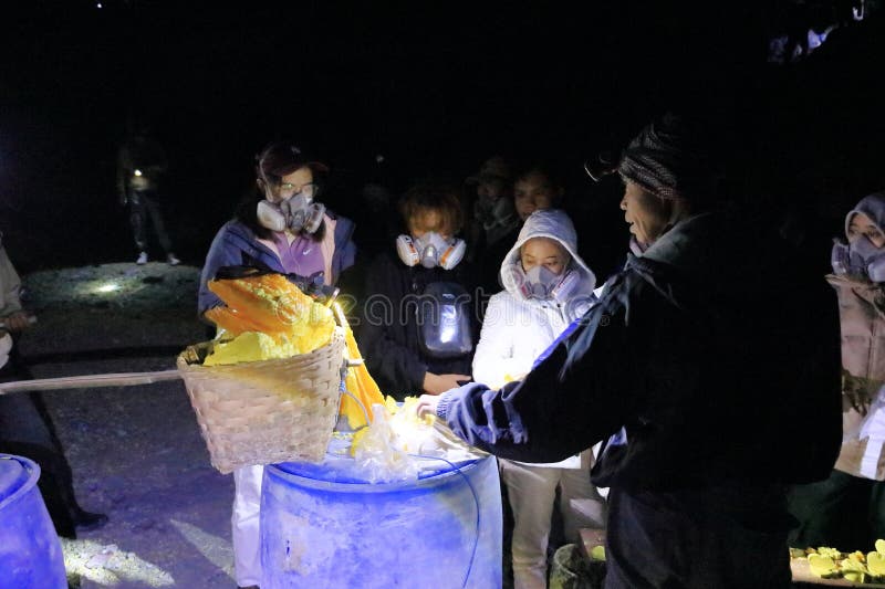 印尼爪哇岛伊真火山 - 2024年2月4日：人们在夜间步行前往火山的蓝色火焰 库存图片