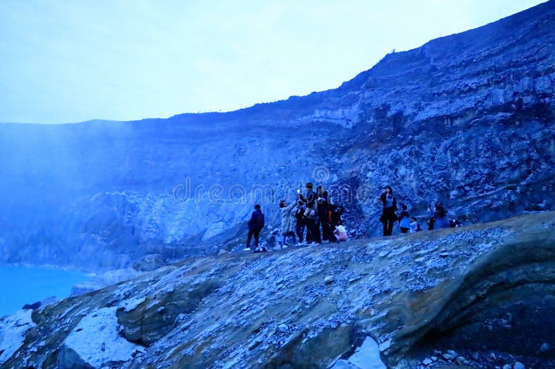 印尼爪哇岛伊真火山 - 2024年2月4日：人们在夜间行走，前往火山的蓝色火焰 免版税库存图片