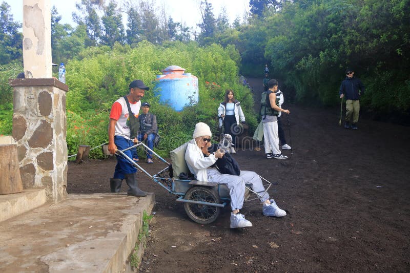印尼爪哇岛伊根火山 - 2024年2月4日：当地人使用出租车马车将游客带到美丽的伊根火山顶 免版税图库摄影
