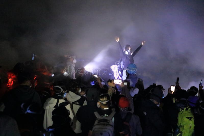 印尼爪哇岛伊真火山 - 2024年2月4日：人们在夜间行走，前往火山陨石坑中的蓝色火焰 库存图片
