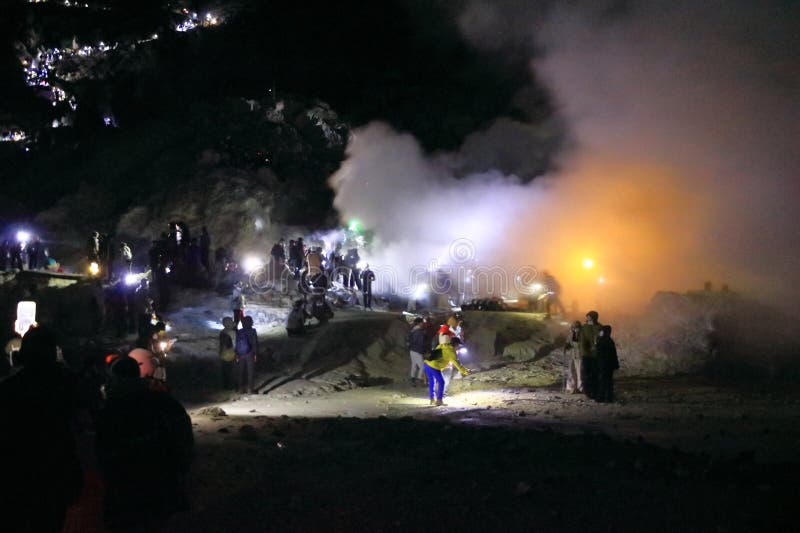 印尼爪哇岛伊根火山 - 2024年2月4日：人们在夜间行走，前往火山的蓝色火焰 免版税库存图片
