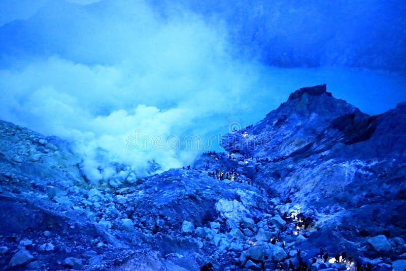 印尼爪哇岛伊根火山 - 2024年2月4日：人们在夜间行走，前往火山火山口的蓝色火焰 库存照片