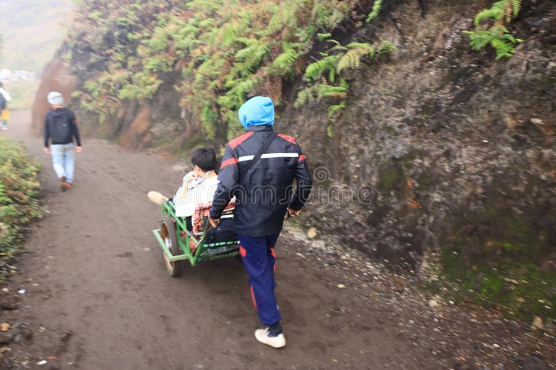 印尼爪哇岛伊根火山 - 2024年2月4日：当地人使用出租车马车将游客带到美丽的伊根火山顶 库存图片