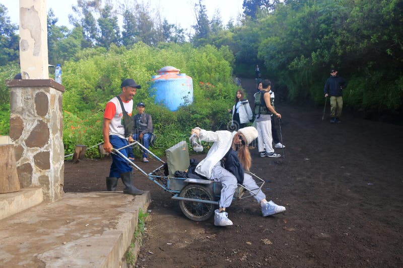 印尼爪哇岛伊根火山 - 2024年2月4日：当地人使用出租车推车将游客带到美丽的伊根火山顶 图库摄影