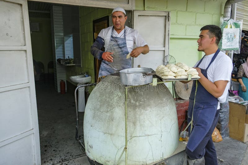 Jayma bazaar in osh kyrgyzstan. Osh kyrgyzstan den 6 oktober 2023 : en man som gör prov i en lerugn vid jayma bazaar i osh kyrgyzstan