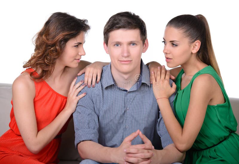 Love triangle. Two angry women looking at each other while men sitting between them. Love triangle. Two angry women looking at each other while men sitting between them