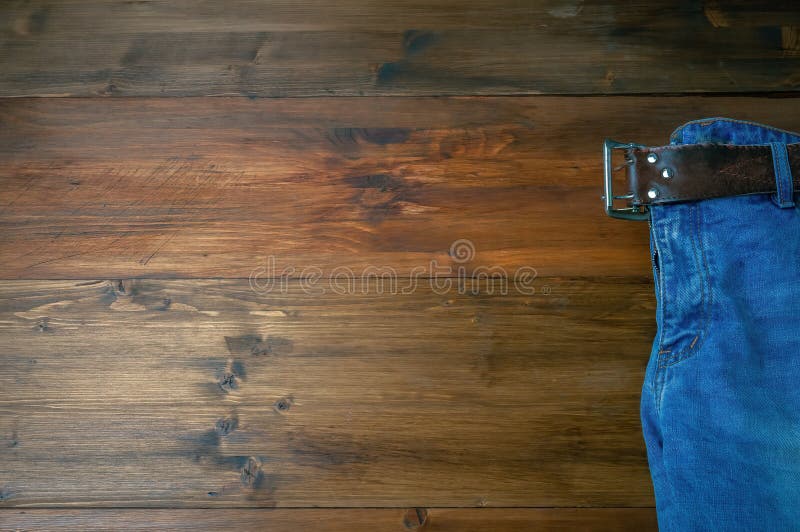 Jean bleu sur fond de bois marron. jeans effilés sur une surface de bois brut. vue supérieure
