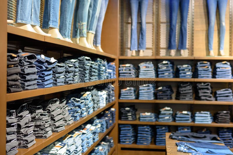 Jeans ordinatamente piegati differenti sugli scaffali del deposito nel centro commerciale fotografia stock libera da diritti Jeans ordinatamente piegati differenti sugli scaffali del deposito nel centro commerciale fotografia stock libera da diritti