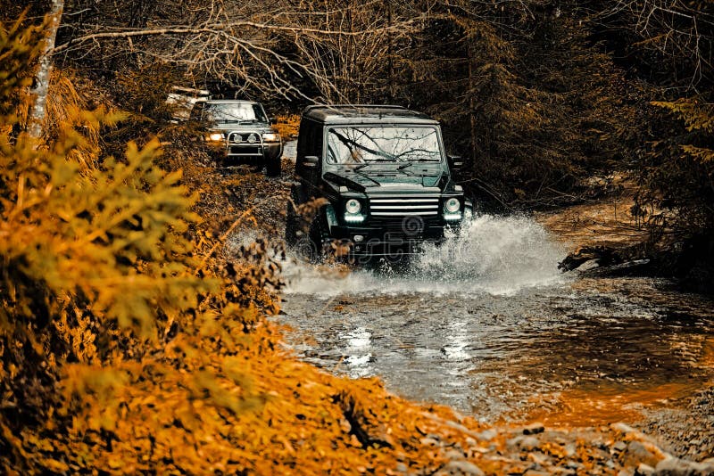 Jeep crashed into a puddle and picked up a spray of dirt. Mud and water splash in off-road racing. Off the road travel