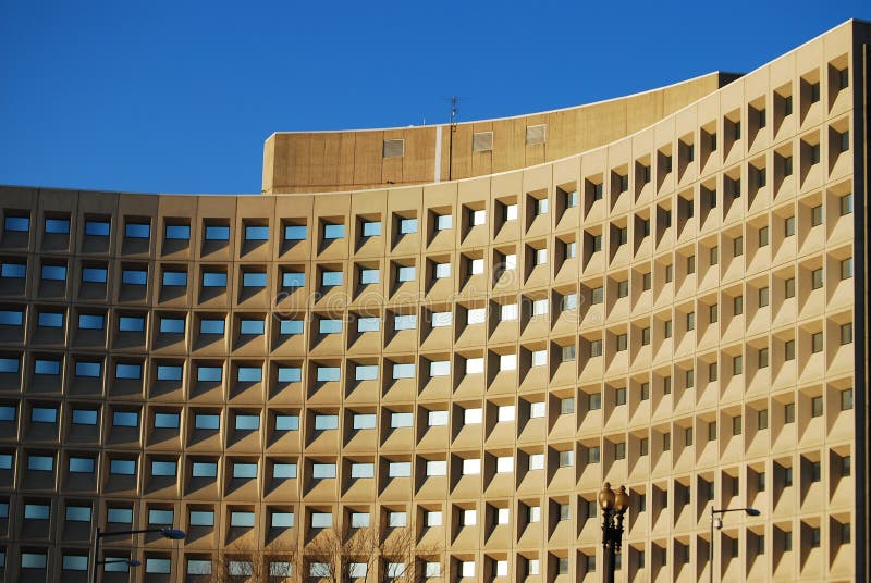 US Department of Housing and Urban Development headquarters in Washington, DC. A coffered facade set against a brilliant blue sky curves through the frame, going from bright to shadow, with windows in the coffers reflecting the sky. US Department of Housing and Urban Development headquarters in Washington, DC. A coffered facade set against a brilliant blue sky curves through the frame, going from bright to shadow, with windows in the coffers reflecting the sky.