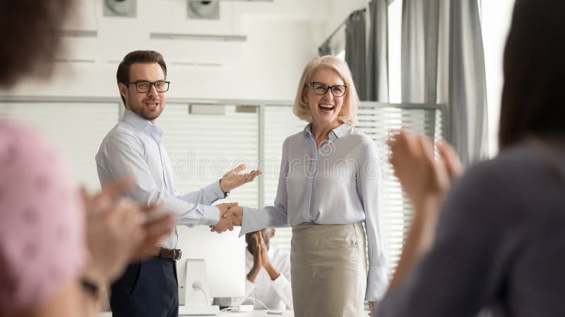 Jefe feliz del encargado que elogia al viejo empleado para conseguir el aprecio del equipo Jefe feliz del encargado que elogia al viejo empleado para conseguir el aprecio del equipo