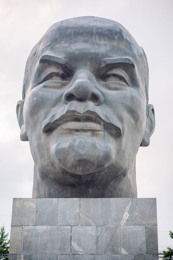 Jefe monumental de piedra de vladimir lenin fundador de la unión soviética parado alto contra un cielo nublado imagen de archivo libre de regalías