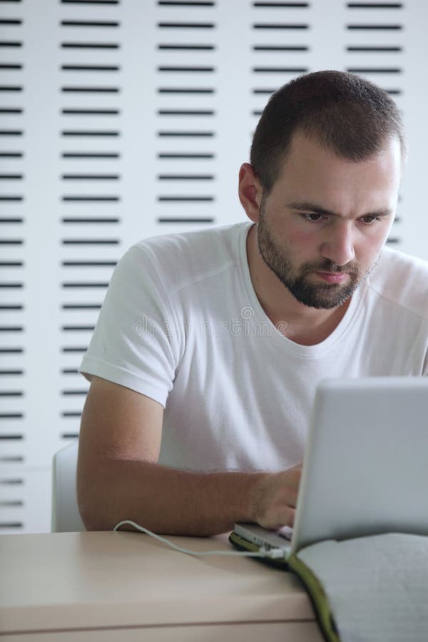 jego laptopu męskiego ucznia działanie zdjęcie stock jego laptopu męskiego ucznia działanie zdjęcie stock