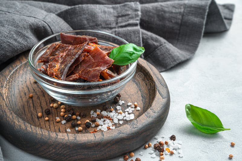 Jerky Meat with Basil and Spices on a Gray Background with a Gray