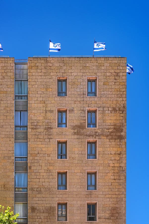 Jeruzalem Israel 12-052019 View of a tall stone building with windows and balconies and Israel flags side on the dak, from the si stock afbeeldingen Jeruzalem Israel 12-052019 View of a tall stone building with windows and balconies and Israel flags side on the dak, from the si stock afbeeldingen