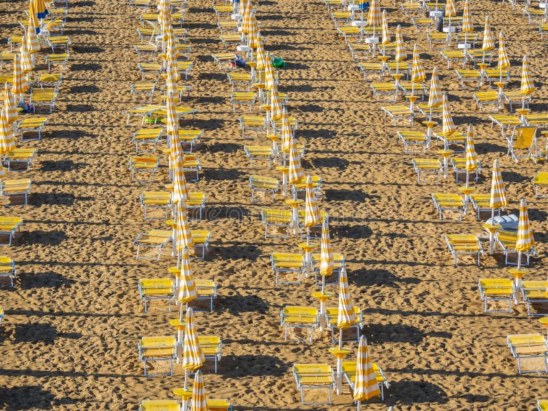 Jesolo italia. ombrelli da spiaggia e letti solari sulla spiaggia italiana di sandy. razze di ombrelli gialli e bianchi. vista aer fotografie stock