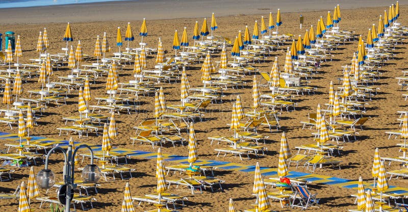 Jesolo italia. ombrelli da spiaggia e letti solari sulla spiaggia italiana di sandy. razze di ombrelli gialli e bianchi. vista aer immagine stock libera da diritti