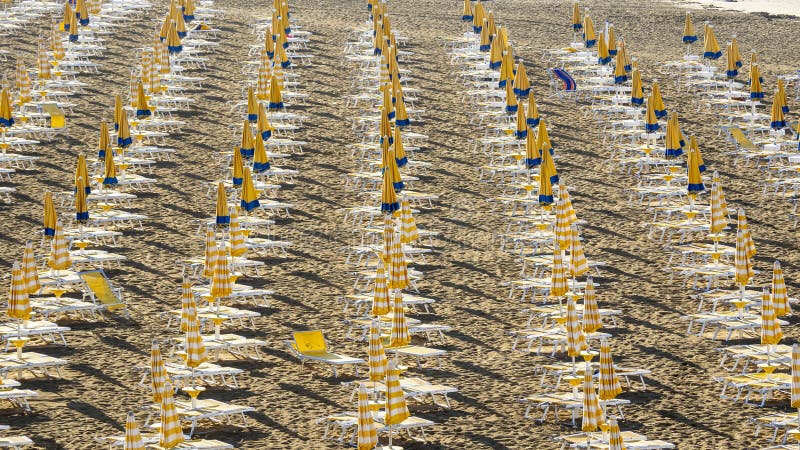 Jesolo italia. ombrelli da spiaggia e letti solari sulla spiaggia italiana di sandy. razze di ombrelli gialli e bianchi. vista aer immagini stock libere da diritti