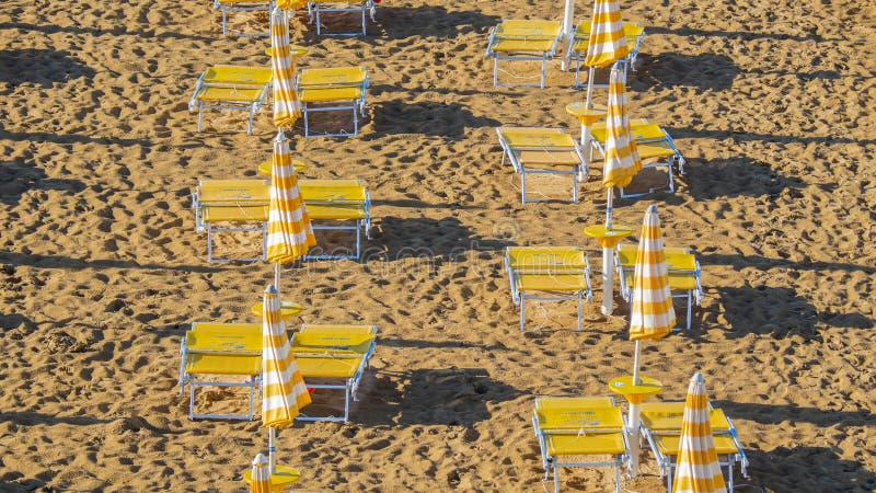 Jesolo italia. ombrelli da spiaggia e letti solari sulla spiaggia italiana di sandy. razze di ombrelli gialli e bianchi. vista aer fotografia stock