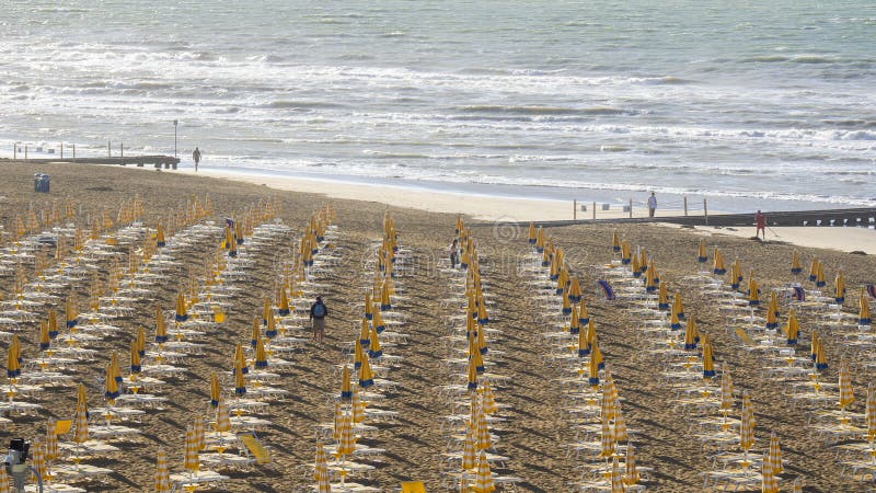 Jesolo italia. ombrelli da spiaggia e letti solari sulla spiaggia italiana di sandy. razze di ombrelli gialli e bianchi. vista aer immagine stock libera da diritti
