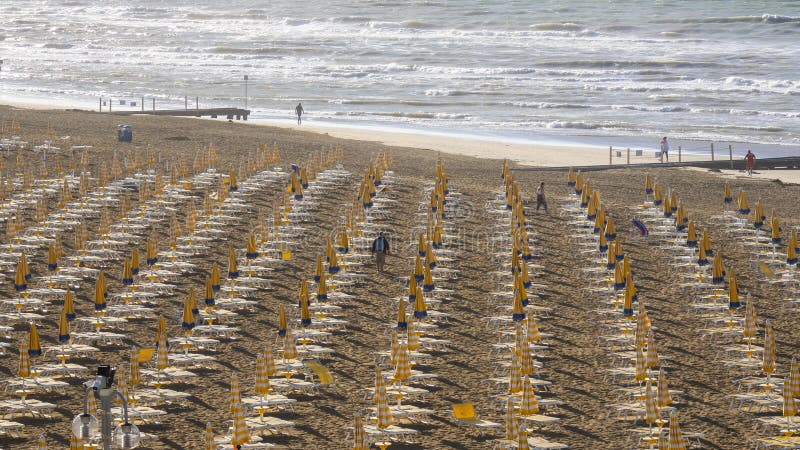 Jesolo italia. ombrelli da spiaggia e letti solari sulla spiaggia italiana di sandy. razze di ombrelli gialli e bianchi. vista aer immagini stock