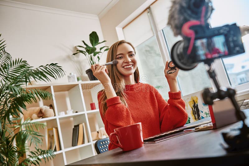 Jest piękny! Śliczny i młody blogger używa muśnięcie stosować piękno produkt podczas gdy nagrywający nowego wideo tutorial obrazy royalty free Jest piękny! Śliczny i młody blogger używa muśnięcie stosować piękno produkt podczas gdy nagrywający nowego wideo tutorial obrazy royalty free
