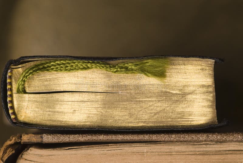 Two old books. One with gold colored pages and plaited bookmark. Two old books. One with gold colored pages and plaited bookmark.