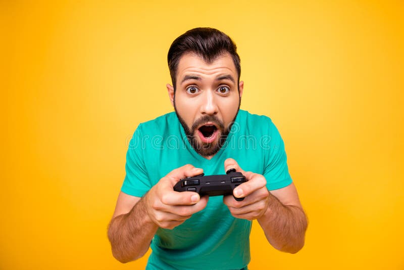 I am number one in playing games! Close up portrait of funny joyful cheerful happy guy, he is rejoicing his victory with gamepad in hands, isolated on bright yellow background. I am number one in playing games! Close up portrait of funny joyful cheerful happy guy, he is rejoicing his victory with gamepad in hands, isolated on bright yellow background