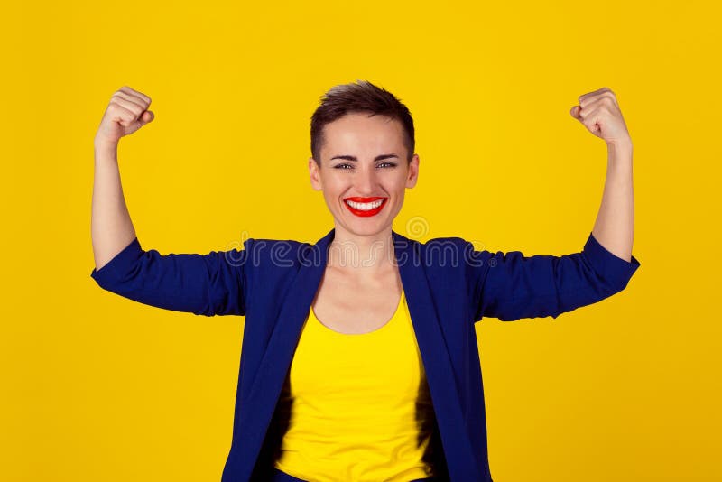 I am powerful and happy. Portrait of a happy elegant business woman showing power her biceps on yellow background. Multicultural Latina girl short hair red lips blue suit yellow shirt. I am powerful and happy. Portrait of a happy elegant business woman showing power her biceps on yellow background. Multicultural Latina girl short hair red lips blue suit yellow shirt