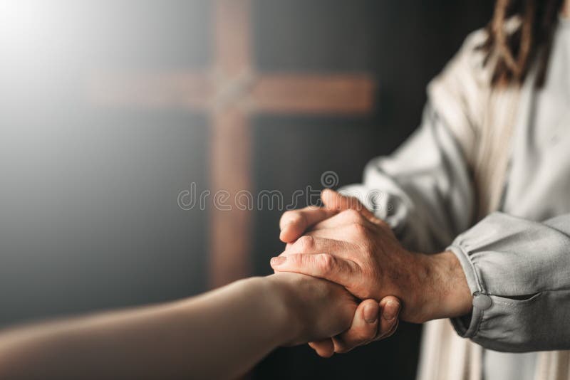 Jesus Christ gives a helping hand to the faithful. Jesus Christ in white robe gives a helping hand to the faithful, crucifixion cross on background. Son of God stock photography