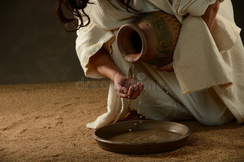 Jesus pouring water. From a jug royalty free stock images