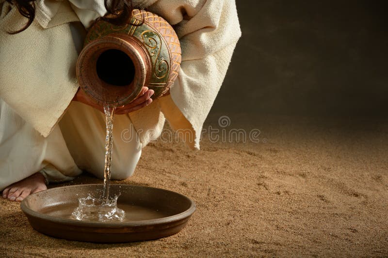 Jesus Pouring Water. From jug over dark background royalty free stock photo