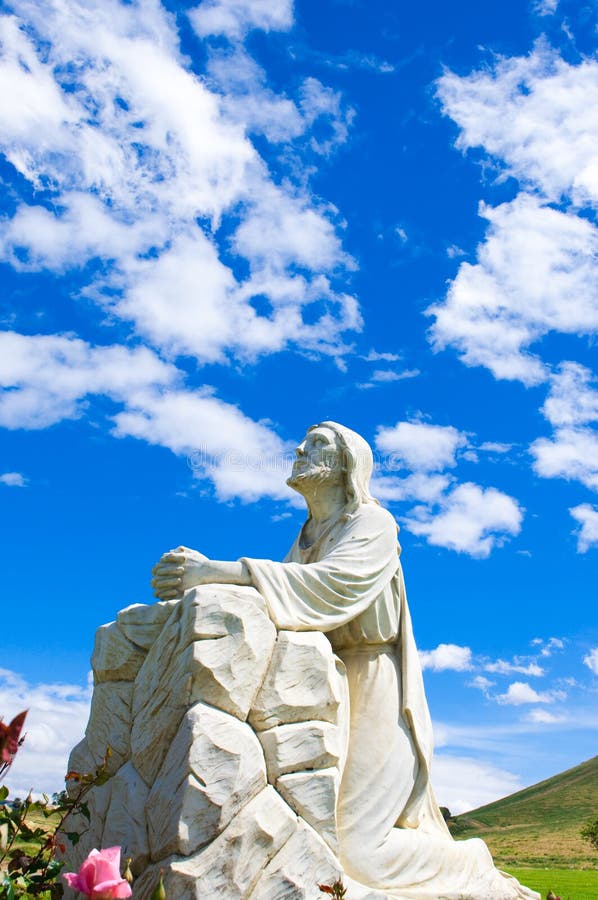 A statue of Jesus with a blue sky and clouds at a cemetery in Riverside,CA. A statue of Jesus with a blue sky and clouds at a cemetery in Riverside,CA.