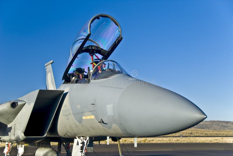 American jet fighter (f series) on airfield, cockpit open.