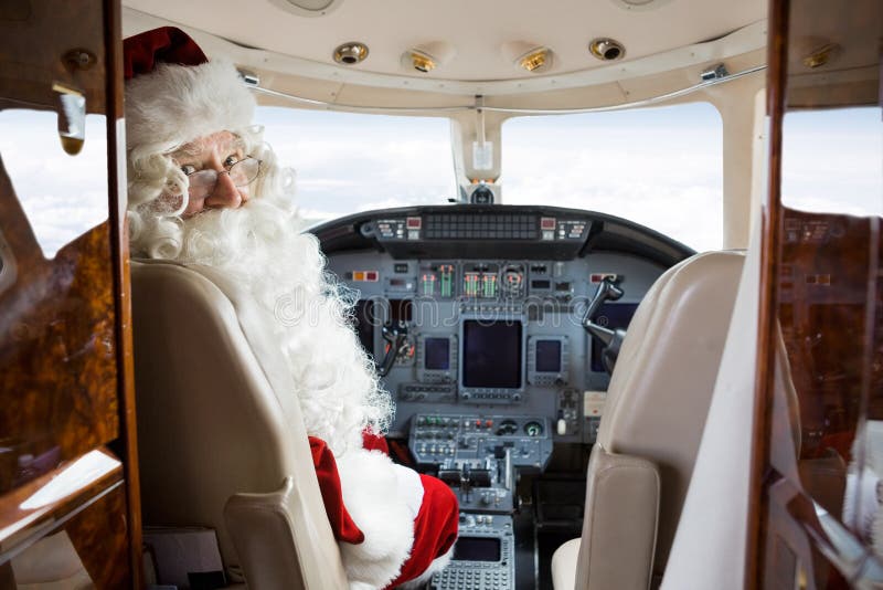 Jet privé de Santa Sitting In Cockpit Of images libres de droits Jet privé de Santa Sitting In Cockpit Of images libres de droits
