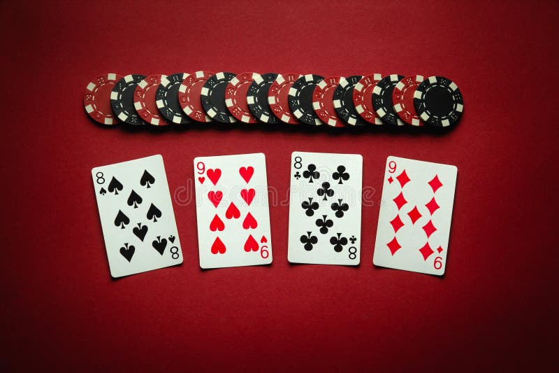 Chips and playing cards with a winning combination of two pairs on a red table. Concept of luck or winning in poker club. Winning at a casino depends on luck. Chips and playing cards with a winning combination of two pairs on a red table. Concept of luck or winning in poker club. Winning at a casino depends on luck.