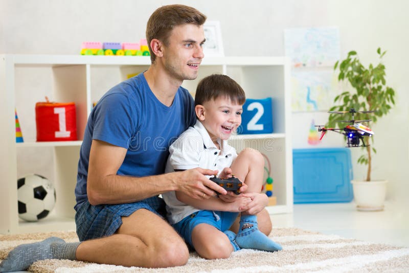 Jeu d'enfant et de père avec l'hélicoptère contolling images libres de droits